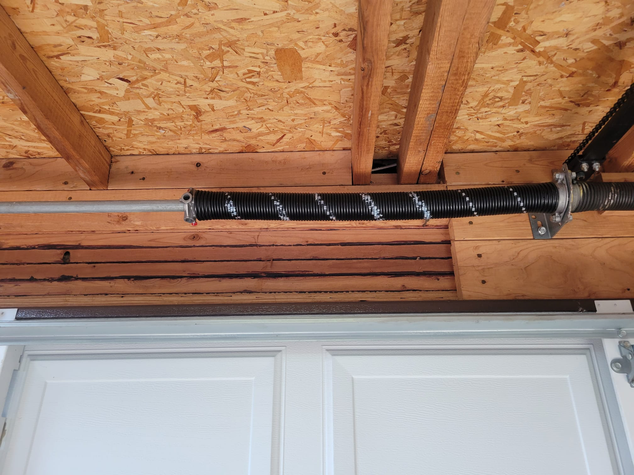Garage door spring repaired and secured after adjustment