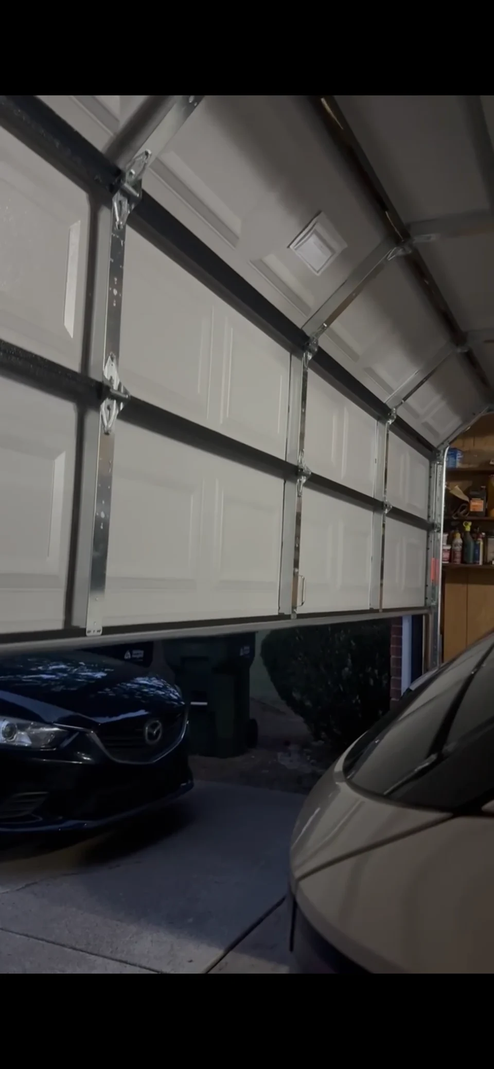 White sectional garage door with interior hinges and track hardware