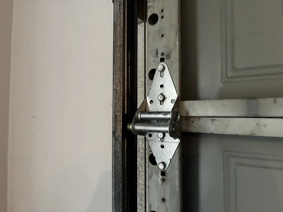 New garage door hinge installed after replacement