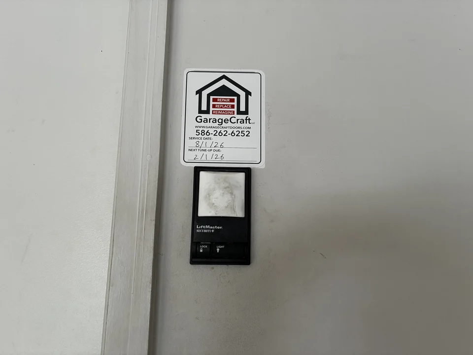 Technician performing a tune up on garage door components before hinge replacement