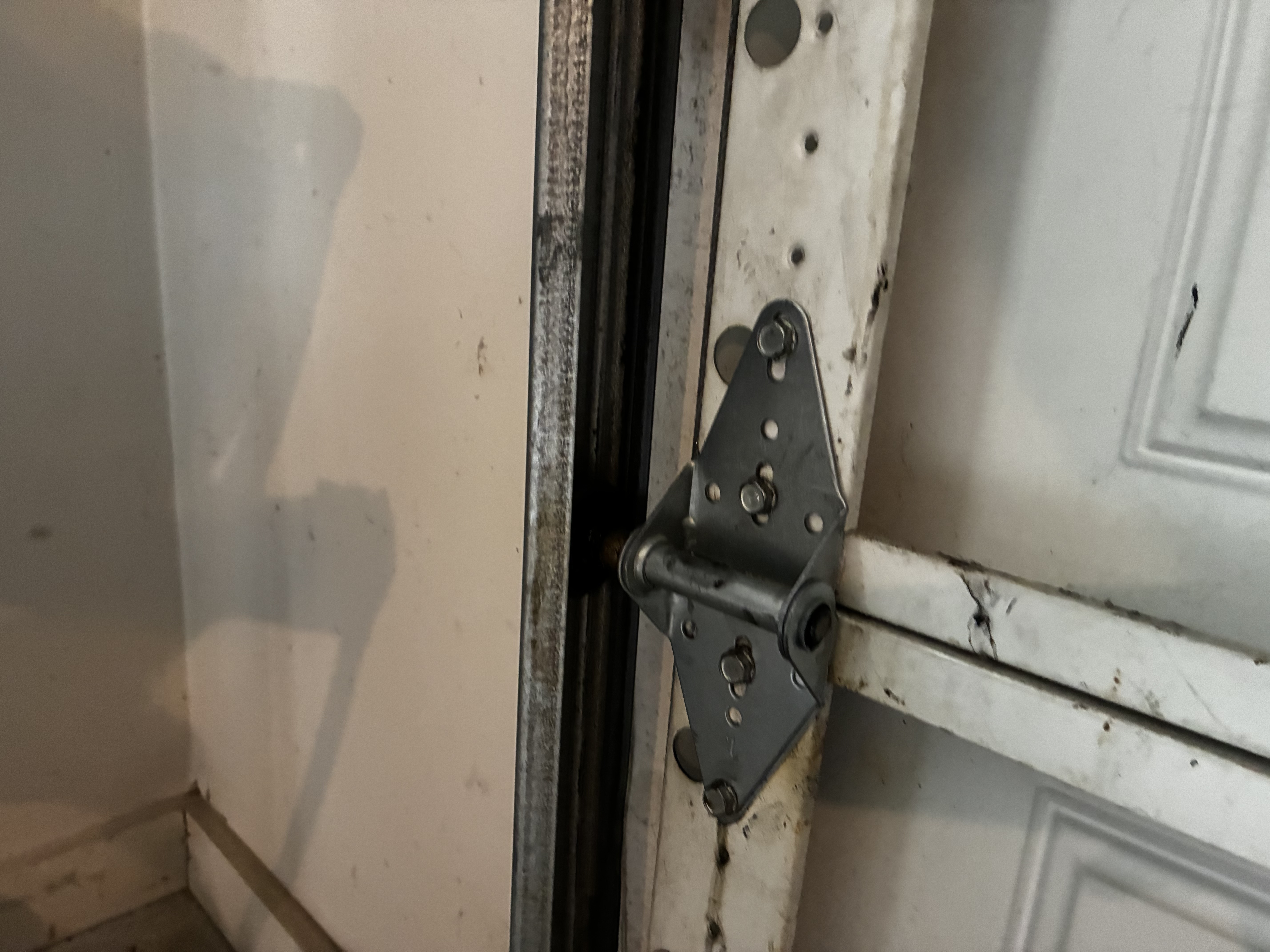Old garage door hinge showing wear before replacement
