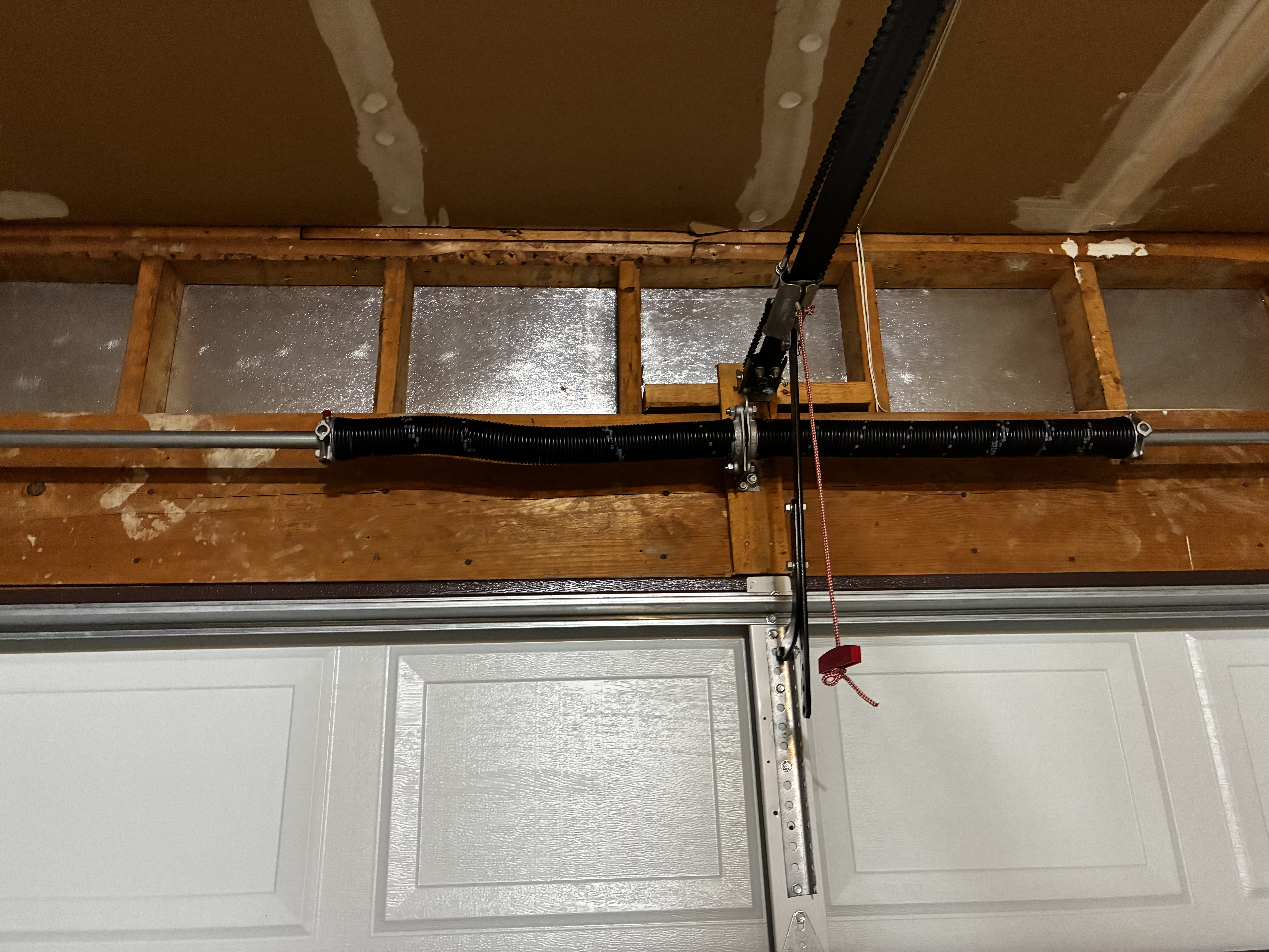 Garage door torsion spring tensioned and adjusted properly